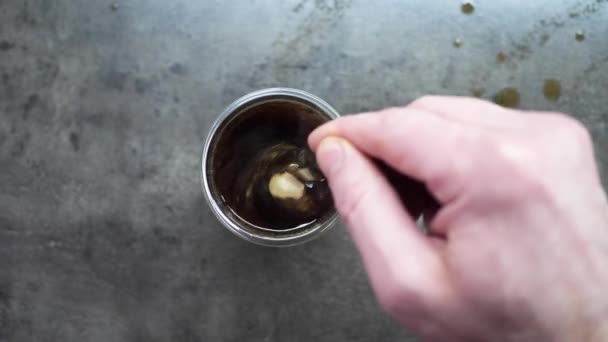 Vista dall'alto di Persona mano sterzo caffè in una tazza con cucchiaio. Mattina di colazione di una tazza di caffè nero caldo su sfondo di legno. scena del filmato HD. casa facendo il caffè — Video Stock
