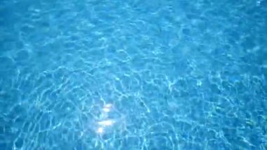 Saf parlak ve rahatlatıcı açık mavi sular. Etkileyici bir arka plan. Dalgalanmalar, yazın açık havada yüzme havuzunda dalgalanmalar.