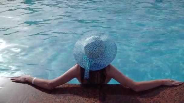 Takana nainen sininen hattu nojaten altaan rajalla sisällä uima-allas peitetty Mozaic laatta, malli kopioi tilaa, koholla näkymä — kuvapankkivideo