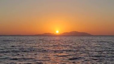 Deniz videosundaki kırmızı günbatımları Full HD. Güneş ufukta beliriyor. Kızıl gökyüzü, sarı güneş ve inanılmaz deniz. Yaz günbatımı deniz manzarası. Kızıl deniz günbatımı. Fantastik doğal gün batımı