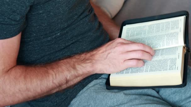 En mann leser Bibelen. Videoopptak fra øverste visning, 4k. Religionskonseptet snakker hellig mann med Gud hver morgen – stockvideo