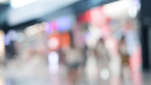 Menschen kaufen auf dem Markt ein. Hintergrund in Einkaufszentrum verschwimmen lassen. Männer und Frauen gehen und backen Kleidung. 4k Videomaterial. Verkaufskonzept — Stockvideo