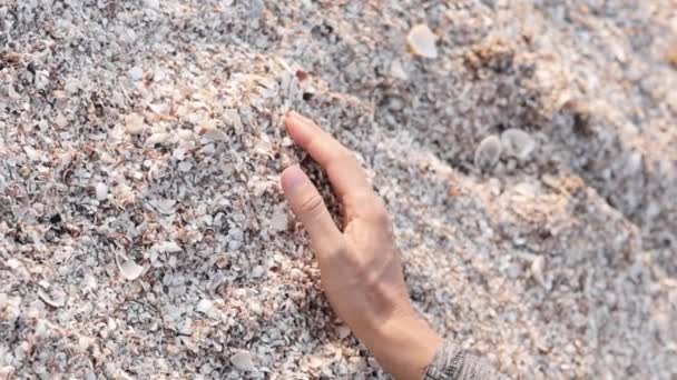 La mano della donna prende la sabbia in mano e la versa fuori. Video Full HD per turismo o relax concept — Video Stock
