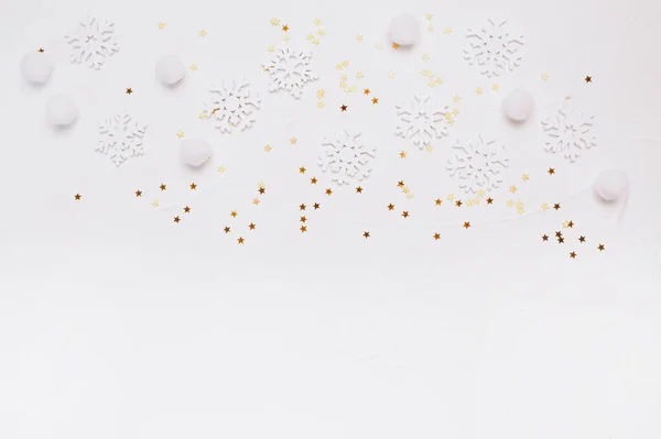 Χριστουγεννιάτικη μακέτα από νιφάδες χιονιού και χρυσά αστέρια λάμπουν σε λευκό φόντο. Χειμερινές διακοπές. Επίπεδη lay top view με θέση για το κείμενό σας — Φωτογραφία Αρχείου