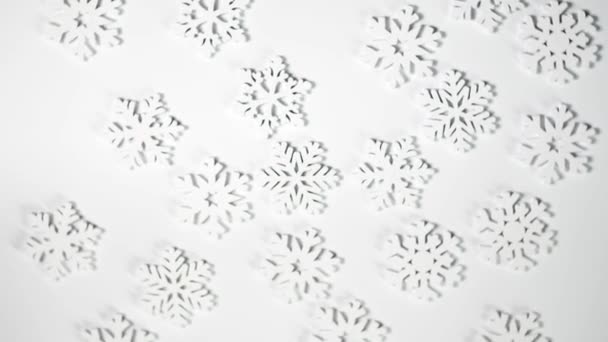 Juguete de Navidad copos de nieve blancos rotan sobre fondo blanco con lugar para el texto. Año Nuevo composición vídeo tarjeta de felicitación 4k metraje — Vídeos de Stock