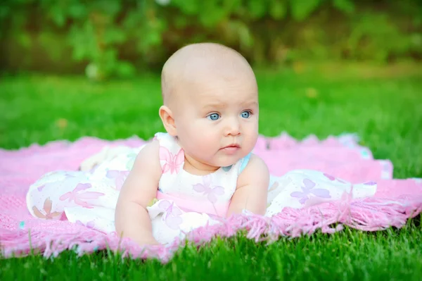 Baby smiling and looking up to camera outdoors in sunlight — Stock Photo, Image