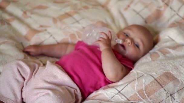 Little baby lying on the bed and drinking milk from a bottle — Stock Video