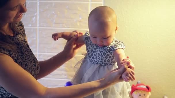 Annem küçük bir kız bebek elbise ona ellerine saklar — Stok video