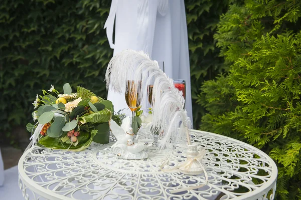 En bröllop bukett är glas med champagne och ringar — Stockfoto
