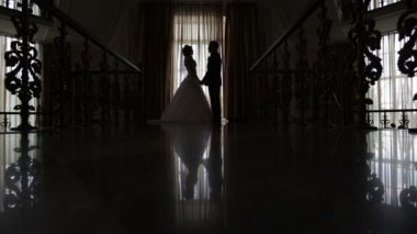 Gelin ve damat salonda pencerenin önünde siluetleri