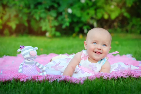 Baby liggend op groen gras in het park — Stockfoto