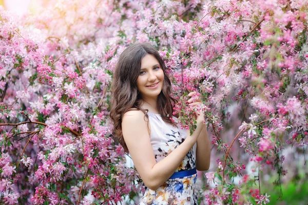 Fashion beautiful girl in a flowers garden — Stock Photo, Image