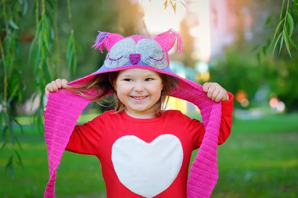 Hermosa risita niña pequeña en un abrigo rojo y colorfu — Foto de Stock