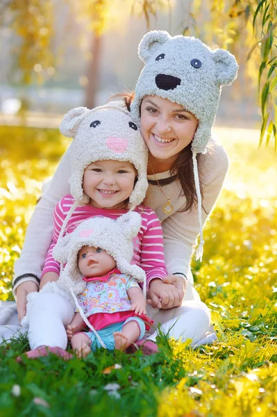 Mädchen mit Puppe in der Mutter und Hüten — Stockfoto