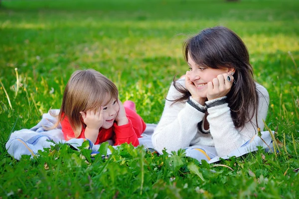 Porträt einer lächelnden schönen jungen Frau und ihrer kleinen Tochter — Stockfoto