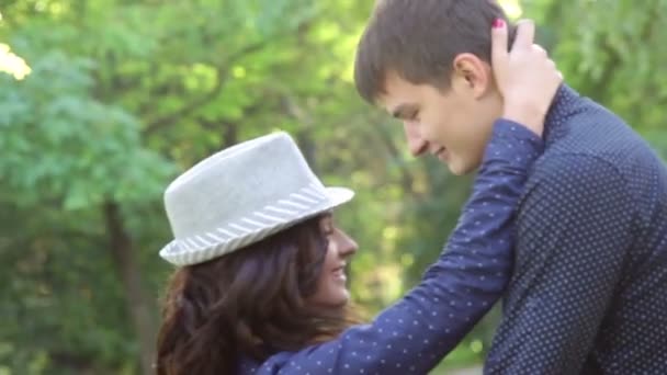 Girl in hat hugging a guy in the park — Stock Video