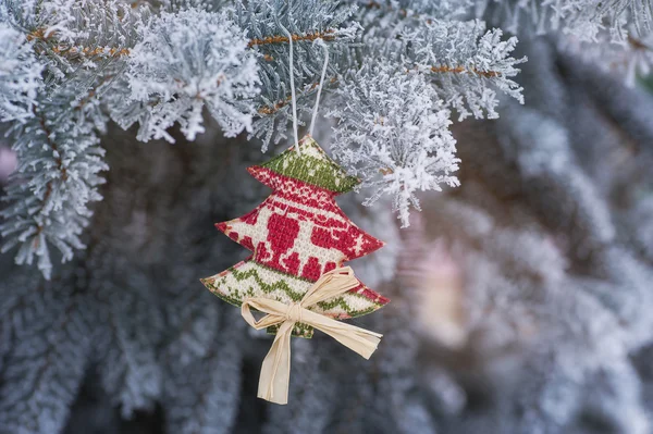 Su un ramo d'albero innevato appeso giocattolo di Natale fatto a mano — Foto Stock