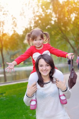 Genç anne ve küçük kızı sonbaharda eğleniyor. 