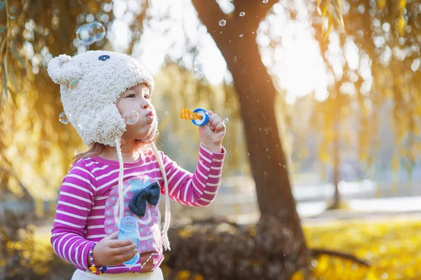 Schattig klein meisje blaast een zeepbel — Stockfoto