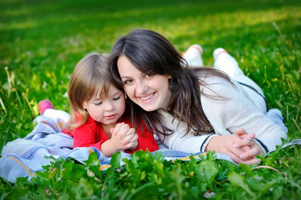 Fille avec mère sur l'herbe dans le parc — Photo