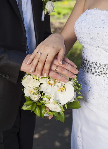 Hände und Ringe am Brautstrauß — Stockfoto