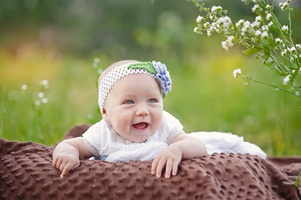 Bebê sorrindo e olhando para a câmera ao ar livre sob a luz do sol — Fotografia de Stock