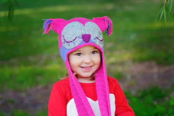 Niedliches kleines Mädchen auf der Wiese an einem Sommertag eine gestrickte Mütze Eule — Stockfoto