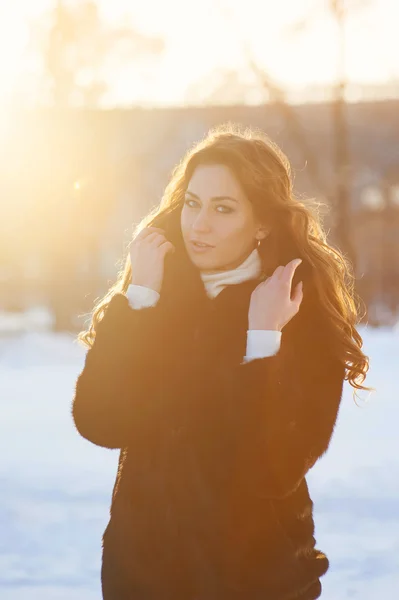 Inverno ragazza nei raggi del sole al tramonto — Foto Stock