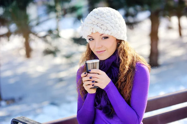 Porträtt av den vackra flickan dricka varma drycker i snöiga wi — Stockfoto