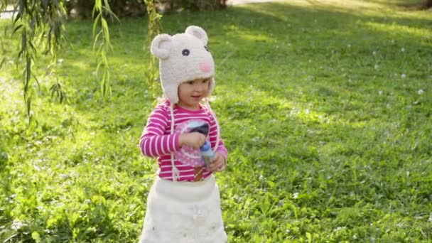 Little girl blowing soap bubbles, closeup portrait — Stock Video