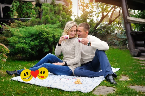 Pareja feliz en la naturaleza bebiendo té al aire libre haciendo un picnic en fa — Foto de Stock