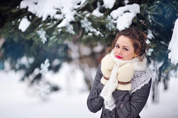 Beautiful blonde woman walking outdoors under snowfall Royalty Free Stock Images