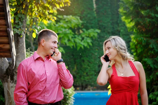 Kız ve adam telefon parkta bahsediyoruz — Stok fotoğraf