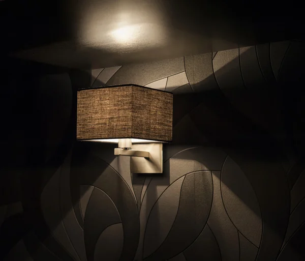 Elektrische Lampe vor einer schwarzen Wand — Stockfoto