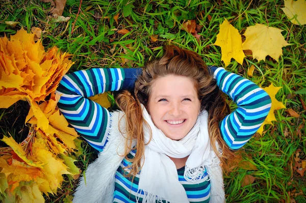 Rire fille couché sur l'herbe à l'automne — Photo