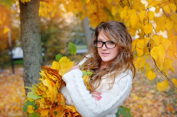美丽的女孩，戴着眼镜在秋天的公园 — 图库照片