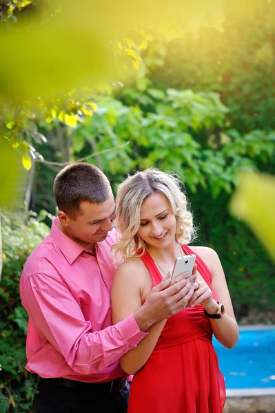 Portrait de jeune couple s'amusant avec des smartphones, en plein air — Photo