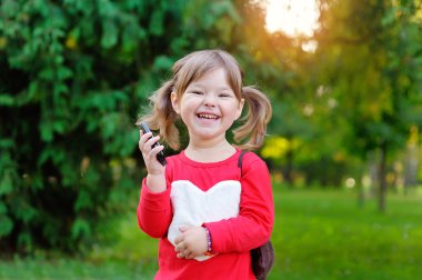 Mutlu kız parkta telefonda konuşuyor