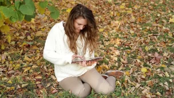Menina sorridente com tablet na paisagem de outono — Vídeo de Stock