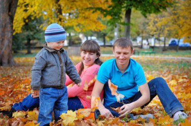 Sırtıma sonbahar parkta oynarken mutlu bir aile 