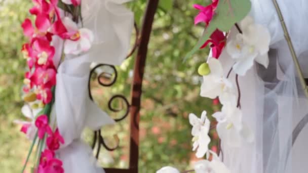 Çimlerin üzerinde çiçekler olan düğün kemeri — Stok video