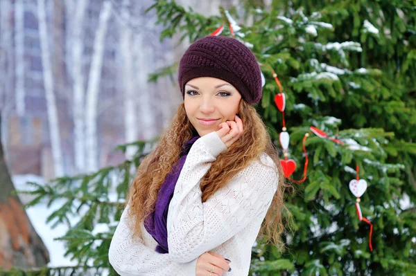 Mooi meisje in de winter op een achtergrond van bomen — Stockfoto