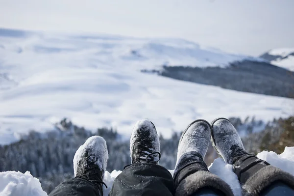 Snötäckta fötter av två vandrare på ett vinterlandskap — Stockfoto