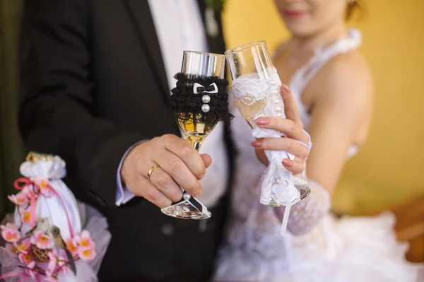 Decorated wedding glasses in the hands of the bride and groom — Stock Photo, Image