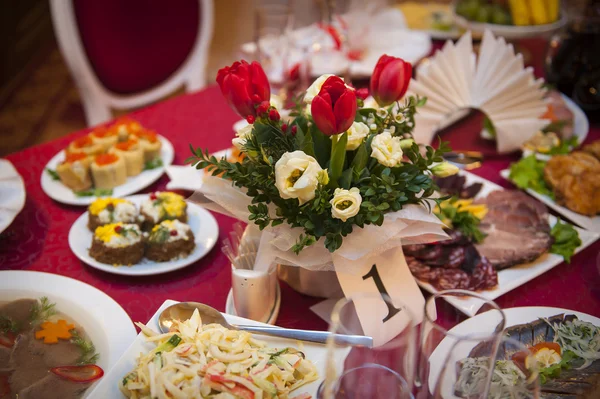 Table setting for a holiday, with red flowers — Stock Photo, Image