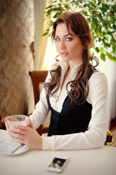 Hermosa chica mirar a la cámara, en un restaurante con una taza —  Fotos de Stock