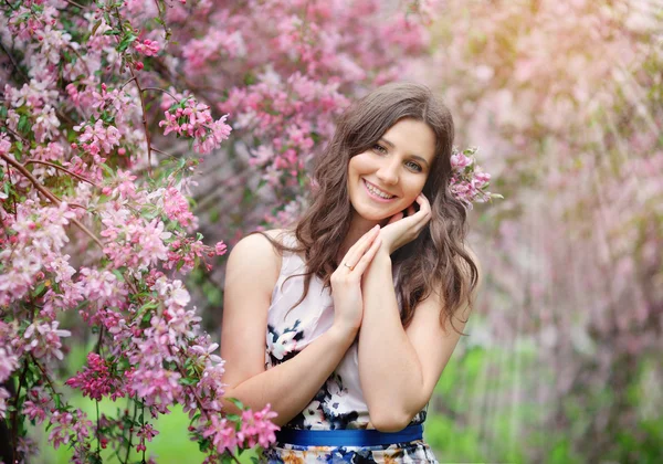 Menina bonita no jardim de primavera entre árvores florescentes com rosa — Fotografia de Stock