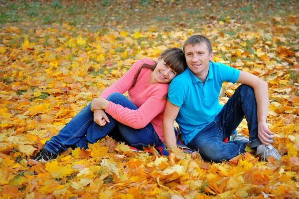 Couple man and woman in autumn yellow leaves — Stock Photo, Image