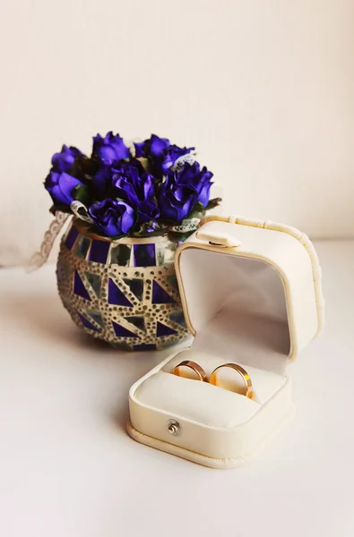 Anillos de boda en una caja en el fondo de las flores — Foto de Stock