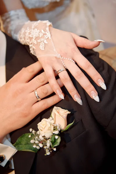 Mani con anelli sul bouquet da sposa — Foto Stock